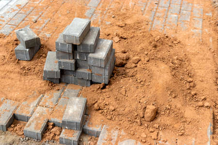 Pavement repairs and paving slabs laying on the prepared surface, with tile cubes in the background. Laying paving slabs in the pedestrian zone of the city. Paving slabs and curbsの写真素材