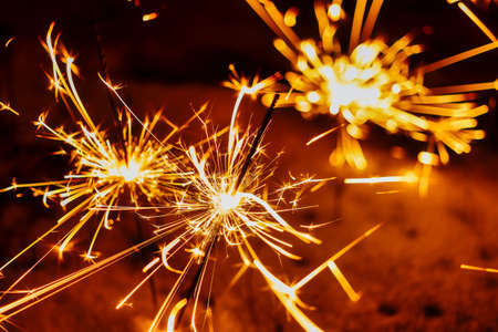 Festive background, bengal light on the dark background, New Year with sparklers sparks on a black backgroundの写真素材