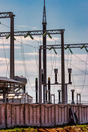 Close-up of electrical substation showing wires, ceramic insulators and birds nesting beneath them