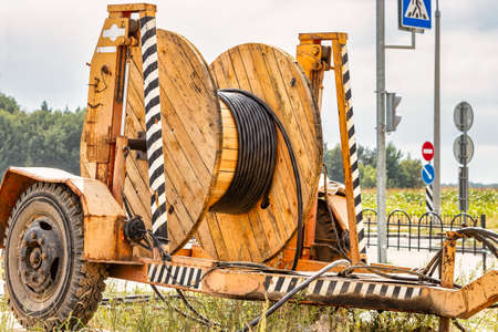 Wooden reel with high voltage cable mounted on a trailer for easy transport and stowage. Laying a...