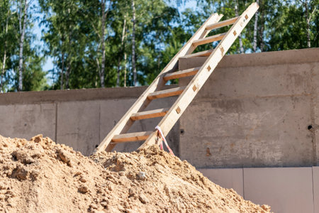 Wooden ladder lies on a construction site. Safety precautions for high-altitude work in constructionの写真素材