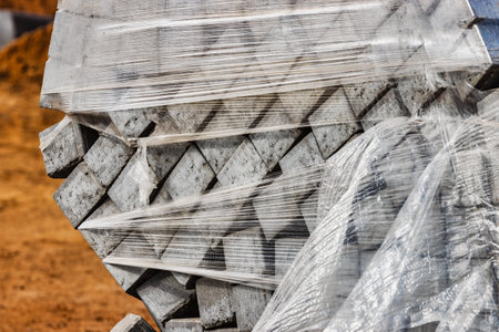 Pavement repairs and paving slabs laying on the prepared surface, with tile cubes in the background. Laying paving slabs in the pedestrian zone of the city. Paving slabs and curbsの写真素材