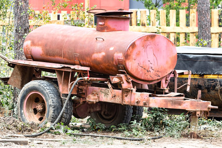 An old barrel on wheels for watering and delivering water to a construction site. Temporary water supply for the construction siteの写真素材