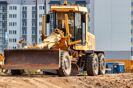Road grader at the construction site. Powerful construction machine for ground leveling and excavation. close-up. professional construction equipmentの写真素材