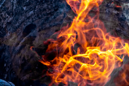 Burning fire close up. Bright orange and red flames on a dark background. open flame heating....