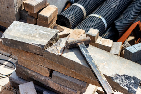 A sledgehammer or hammer made by workers licks on a concrete block at a construction site. Working tool close-upの写真素材