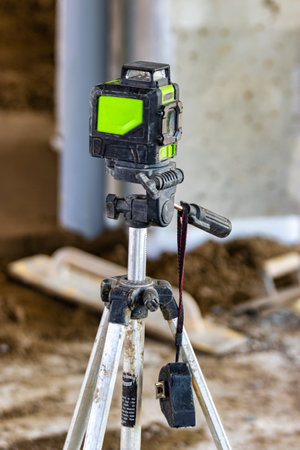 Laser level on a tripod at a construction site. close-up. Taking measurements with a laserの写真素材