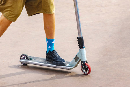A boy on a scooter and in a skate park makes incredible jumps and tricks. Extreme jumping on a...