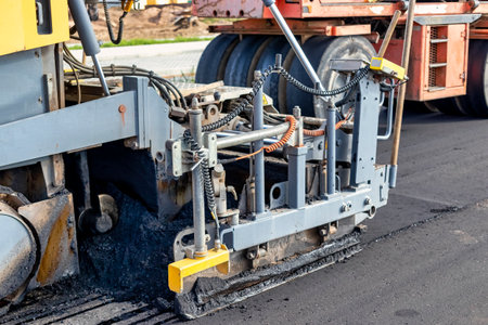 Asphalt laying equipment. Work on the device of a new road surface in a modern city. Powerful...