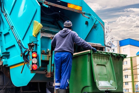 A garbage truck picks up garbage in a residential area. Loading mussar in containers into the car....