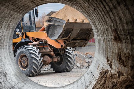 The excavator backfills the pit with the front bucket. Moves soil around the construction site....