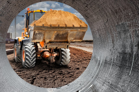 The excavator loader works with a bucket for transporting sand at a construction site. Professional...