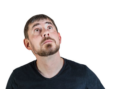 Portrait of an attractive bearded man of European appearance, with a slight gray hair, on an isolated white background. He looks up thoughtfully. Expression of emotions of a manの写真素材