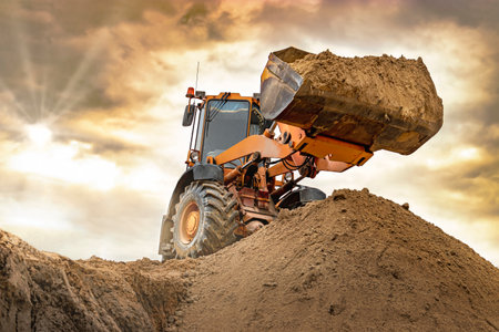 Powerful wheel loader or bulldozer working on a quarry or construction site. Loader with a full...