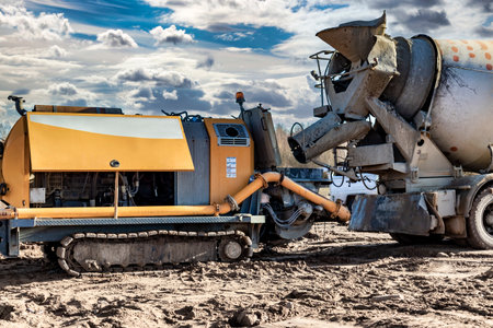 Concrete mixer truck delivers concrete to the pump for pouring piles. Concrete pump at the...