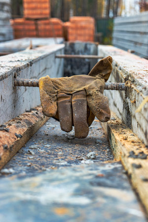 Leather construction gloves on the concrete surface of the foundation. Old worker's gloves on a...