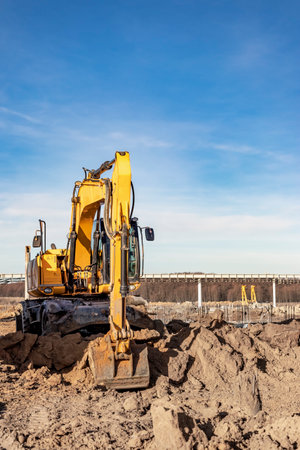 Wheeled works in a pit at a construction site. The excavator carries out excavation work on the...