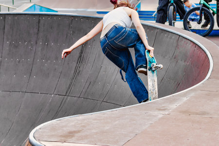 The girl on the skateboard does incredible tricks. sport. Subculture - youth passion for sports. Tricks and jumps on a skateboardの写真素材
