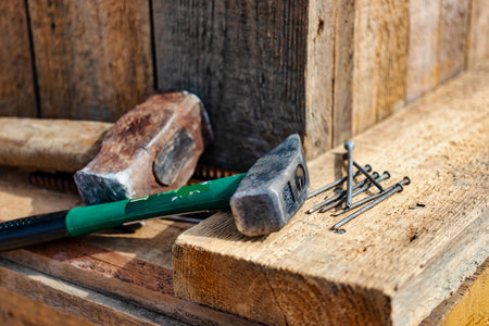 Assembling the wooden formwork of the foundation. Sledgehammer, hammer and self-tapping screws on the wooden formwork of the foundation. Tools for the installer. Preparation for pouring concreteの写真素材