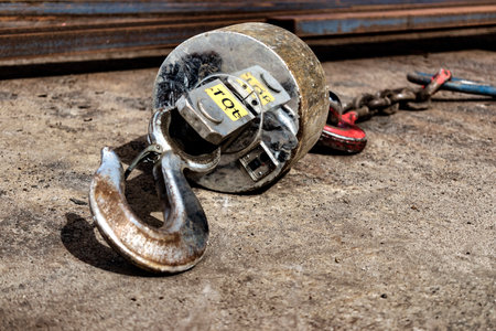 Metal industrial hook on the concrete floor of a steel plant. close-up. Lifting hooks for heavy...