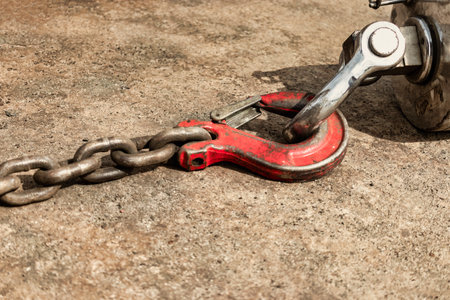 Metal industrial hook on the concrete floor of a steel plant. close-up. Lifting hooks for heavy...