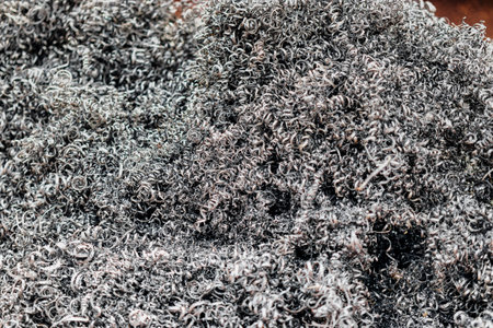 A lot of metal shavings close-up, after working on a milling machine or CNC machine. Texture metal shavings. Recycling of waste. Ecology. Saving resourcesの写真素材