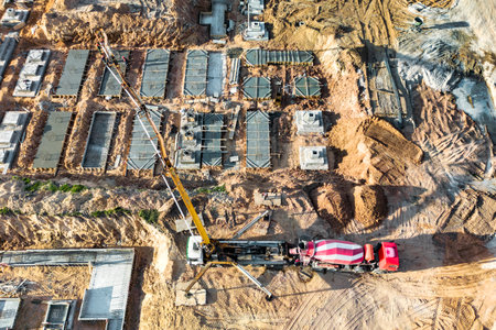 Arm of concrete pump ready for concrete conveying at construction site. Jib of concrete pump truck against sky at background. Truck Mounted Concrete Pump. View from aboveの写真素材