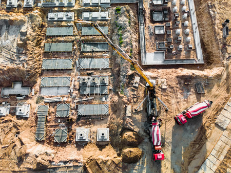Arm of concrete pump ready for concrete conveying at construction site. Jib of concrete pump truck against sky at background. Truck Mounted Concrete Pump. View from aboveの写真素材