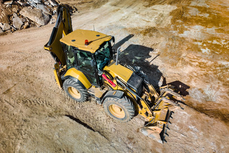 A universal excavator or loader is working on a construction site. close-up. view from above....
