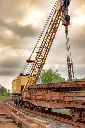 Mobile railway crane on a platform. Replacement and repair of railroad sleepers and other elements. Repair and reconstruction of the railwayの写真素材