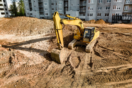 A powerful crawler excavator is working on a construction site. close-up. Preparation of a pit for...