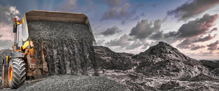 Wheel front loader pour crushed stone or gravel. Spreads crushed stone or gravel with a wide bucket....
