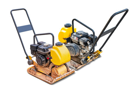 A compact vibrating plate machine is placed. The machine is designed for soil compaction, compacting the ground beneath it. Men at work. Isolatedの写真素材