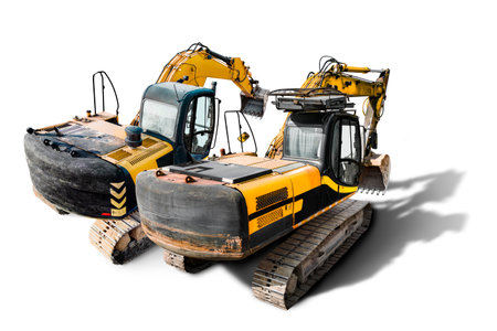 A couple of powerful construction excavators are parked next to each other, ready for use in excavation work at a construction site. Isolatedの写真素材