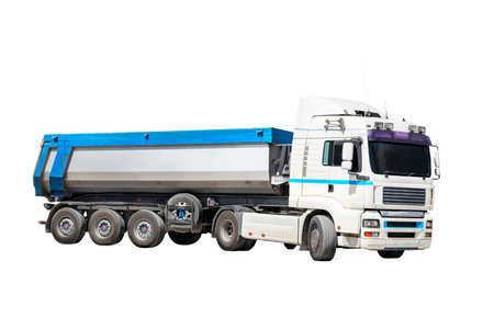 A large dump truck unloads rubble or gravel at a construction site. Car tonar for transportation of heavy bulk cargo. Dump truck isolated on white backgroundの写真素材