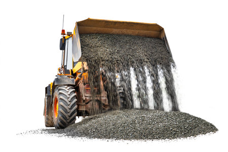 Powerful wheel loader or bulldozer isolated on white background. Loader pours crushed stone or gravel from the bucket. Powerful modern equipment for earthworks. Rental of construction equipmentの写真素材