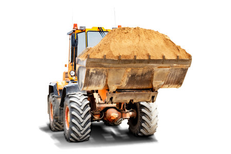 A large front loader transports sand in a bucket at a construction site. Transportation of bulk materials. Isolated loader on a white backgroundの写真素材