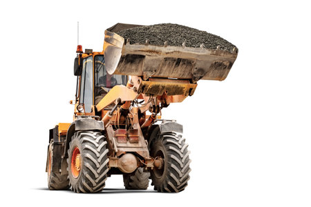 Powerful wheel loader or bulldozer isolated on white background. The loader transports crushed stone or gravel in a large bucket. Powerful modern technology. Rental of construction equipmentの写真素材