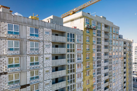 A tall building under construction with a crane on top, symbolizing ongoing development and progress...