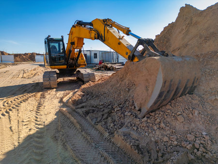 Crawler Excavator Machine Unloading Sand or Soil at Construction Area Background. Close-up of a powerful excavator. Rental of construction equipment. Earthworks contractorの写真素材