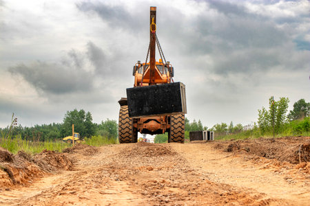 A large industrial loader equipped with a crane mounted on top, ready for heavy lifting and construction work at a construction site.の写真素材