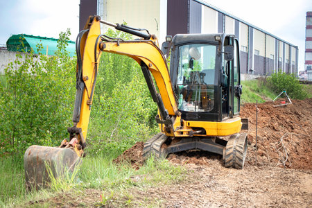 A excavator aggressively excavating soil in a field, creating a path through the earth.の写真素材