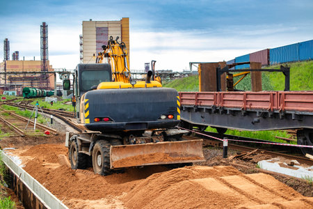 A transport trucking a bulldozer excavator on its flatbed, moving along a road.の写真素材
