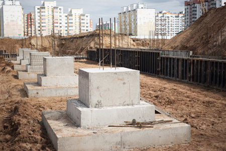 A row of cement blocks stand tall on a dirt field, laying the groundwork for future construction projects at a siteの写真素材