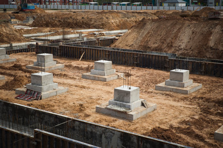 A construction site with reinforced concrete blocks in the foreground, showcasing the buildings beginning stages.の写真素材