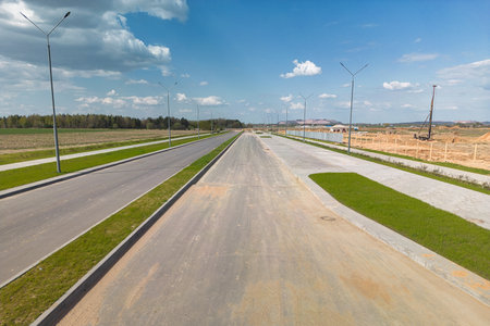 A vast, open road stretches across the frame under a clear blue sky, inviting endless possibilities and freedom.の写真素材