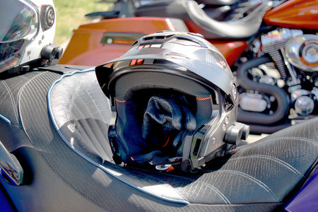 A detailed close up of a sleek, black helmet resting on a motorcycle, ready for the next thrilling adventure.の写真素材