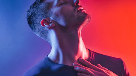 A man, struck by severe pain, clutches his chest, revealing the intense emotion while surrounded by a captivating gradient background of red and blue hues.の素材