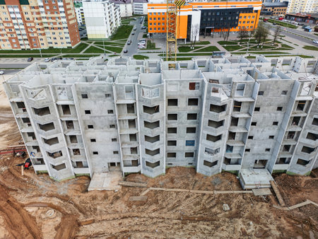 A new concrete apartment complex stands out in a vibrant neighborhood, showcasing innovative architecture and construction.の写真素材