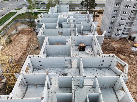 Workers focus on completing layout of a contemporary building, highlighting progress in the urban development of the neighborhood.の写真素材